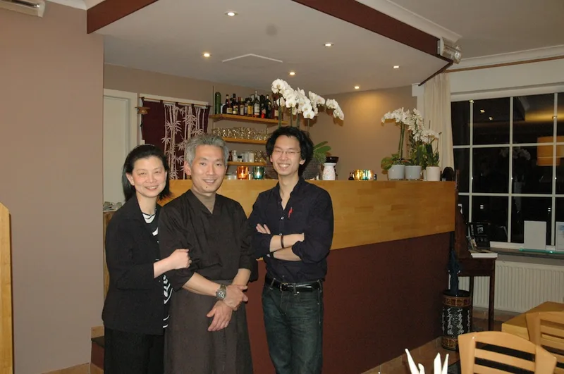 Het team van Tampopo aan de bar met witte orchideeën