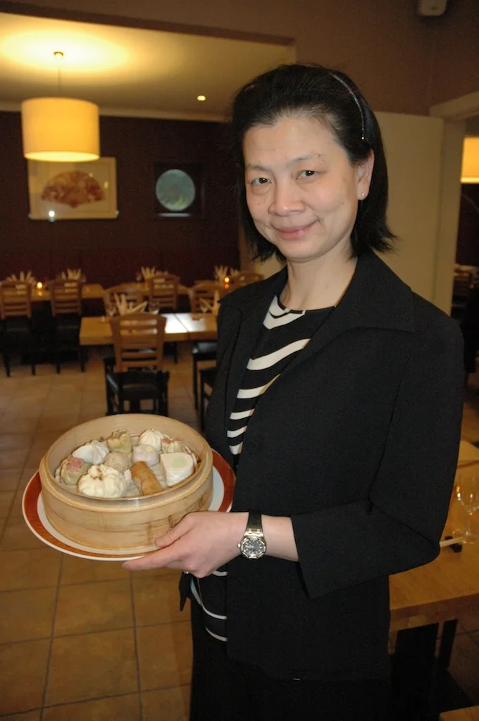 Medewerker van Tampopo met een bamboemandje dim sum in de eetzaal